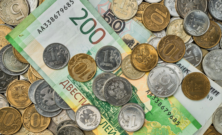 Money, coins and banknotes in Russian rubles scattered in a heap on the table, top view. Idea for background or banner for market news