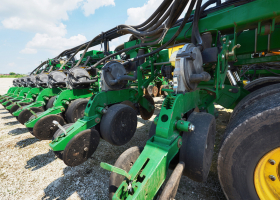 Close up of seeder attached to tractor in field. Agricultural machinery for spring works sowing