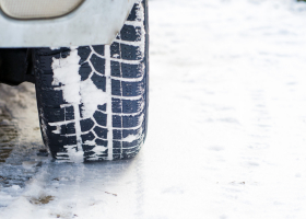 Car tires on winter road covered with snow. Vehicle on snowy all