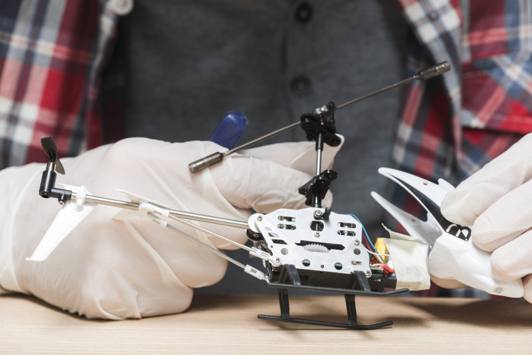 technician-wearing-gloves-repairing-helicopter-toy